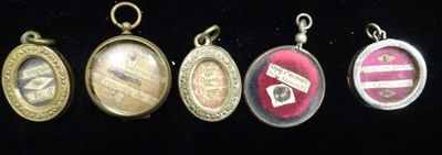 six different types of pendants are displayed on a black surface