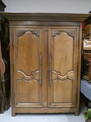 a wooden armoire with two doors on top of it