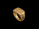 gros plan d'une bague en or sur fond noir
