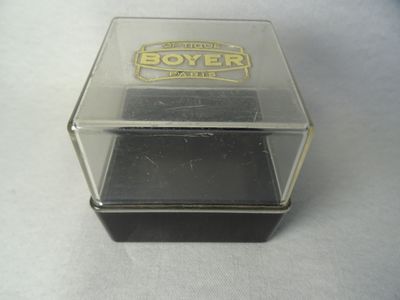 une boîte en verre portant un logo, posée sur une table