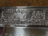a silver plate with a design on it on a table