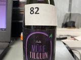 une bouteille d'alcool posée sur une table devant un ordinateur portable