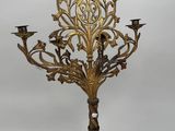 an ornate brass candelab with five candles on a stand