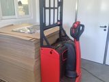 a red fork lift truck with a stack of boxes on it