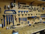 un établi sur lequel sont accrochés de nombreux outils