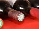 several bottles of wine are lined up on a red table