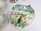 a plate with a picture of a house and flowers on it