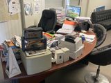 un bureau sur lequel s'entassent beaucoup d'objets