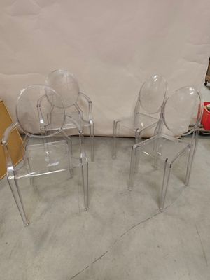 trois chaises en plastique transparent placées les unes à côté des autres dans une pièce