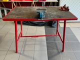 une table rouge sur laquelle repose une pièce de métal