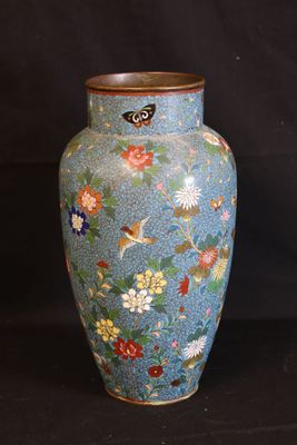 a blue vase with flowers and birds painted on it