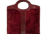 a red sued handbag with a brown leather handle