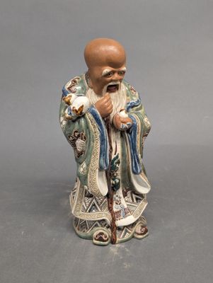 figurine chinoise représentant un vieil homme barbu tenant un oiseau
