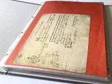 un livre rouge sur lequel sont écrites des notes, posé sur une table