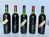 four bottles of wine are lined up on a table