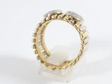 a close up of a gold and silver ring on a white surface