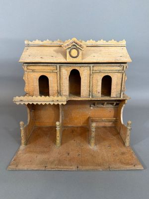 une petite maison de poupées en bois surmontée d'une horloge
