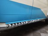 a close up of a blue and white truck with a tire