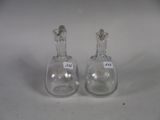two small glass vases sitting next to each other