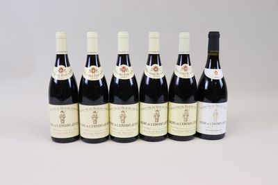 six bouteilles de vin alignées sur une surface blanche
