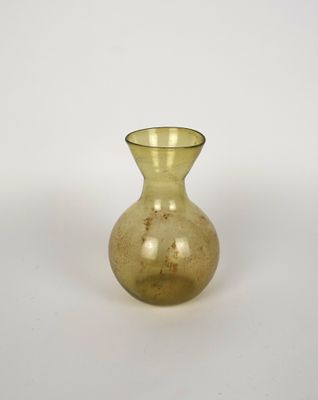 un petit vase jaune posé sur une surface blanche