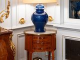a blue vase sitting on a small table in a room