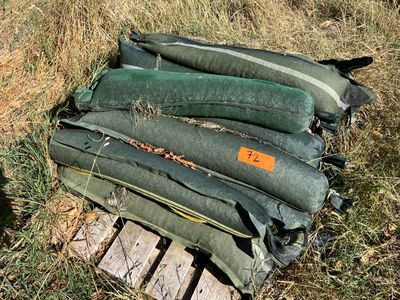 une pile de sacs posée sur une palette dans l'herbe