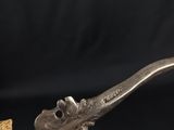 an old pipe with a wooden handle on a black background