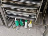 a stack of papers on a metal shelf in a kitchen