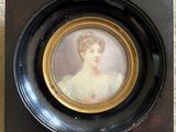 painting of a woman in a white dress in a black and gold frame