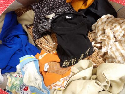 un panier rempli de vêtements posé par terre dans une pièce