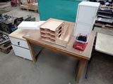 une photo d'un établi dans un atelier, sur lequel sont posés de nombreux outils