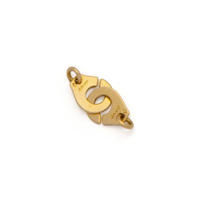 a gold plated charm with the letter g on it