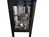 une petite armoire noire surmontée d'un miroir