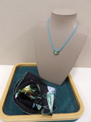 un collier et une écharpe posés sur un plateau posé sur une table