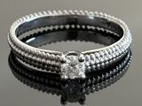 a close up of a diamond ring on a black surface
