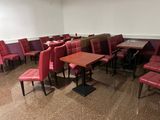 des rangées de fauteuils et de tables en cuir rouge dans une pièce aux murs blancs