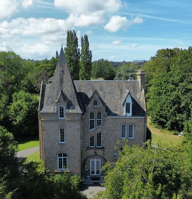 une vue aérienne d'un grand bâtiment en pierre entouré d'arbres