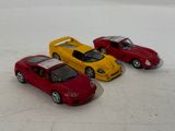 three toy cars that are sitting on a white surface