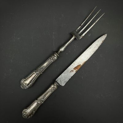 deux fourchettes et un couteau posés sur une table noire