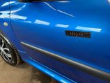 a close up of a blue car with a sticker on it