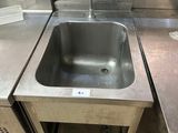 a sink in the middle of a stainless steel counter