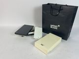 un sac noir et blanc, un téléphone et un bloc-notes posés sur une table