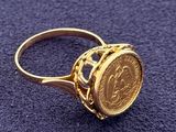 an image of a gold ring with a coin in the middle