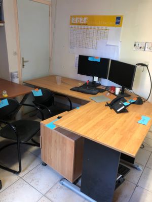 a desk with two computer monitors and a phone on it