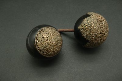 pair of black and gold metal knobs on a black surface