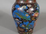 un vase bleu avec des fleurs posé sur une table