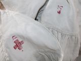 a pile of white pillows with red hearts on them