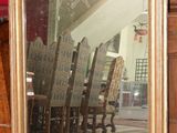 un grand miroir posé par terre à côté d'une chaise