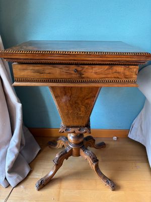 a small wooden table with a drawer on top of it